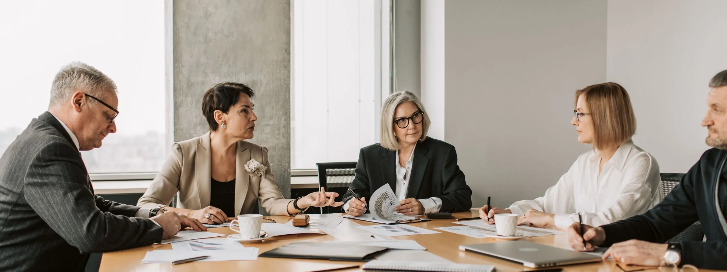 Equipo directivo reunido alrededor de una mesa de juntas